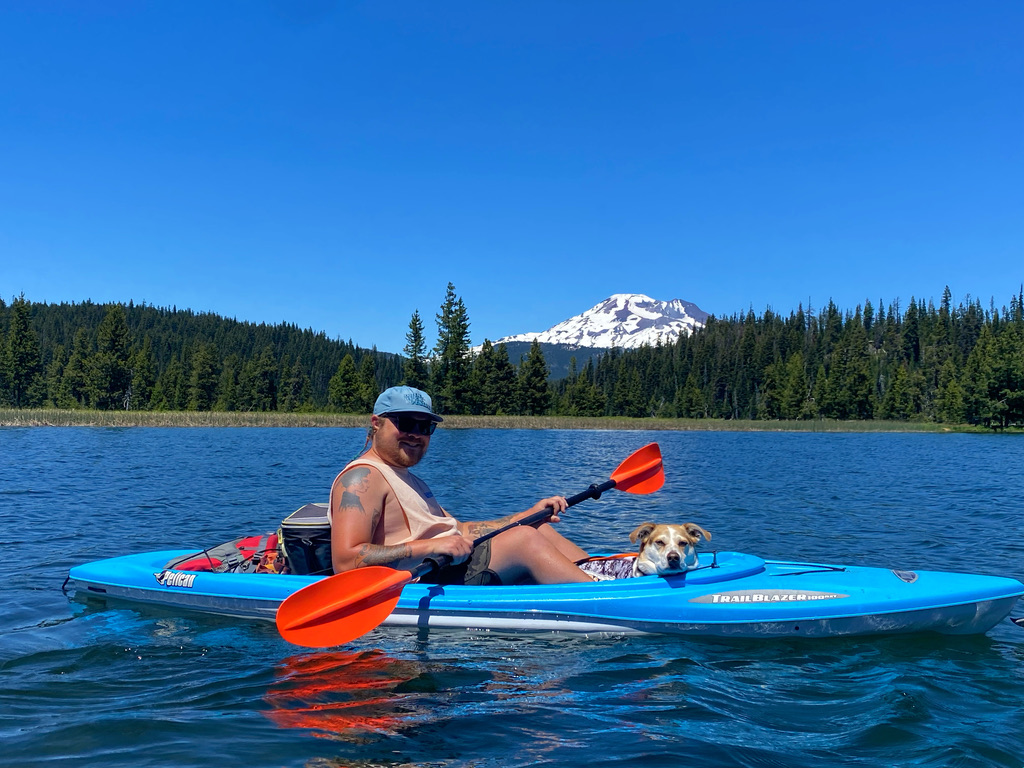 Cam kayaking with his dog on a mountain lake